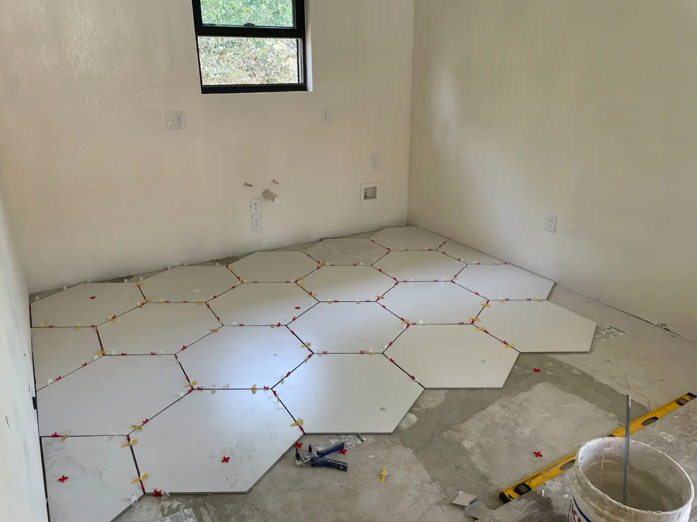 Hexagon floor tile being laid in the casita bathroom