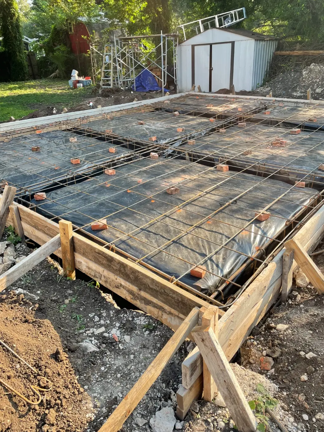 Rebar grid and vapor barrier laid out in wood forms for the foundation pour