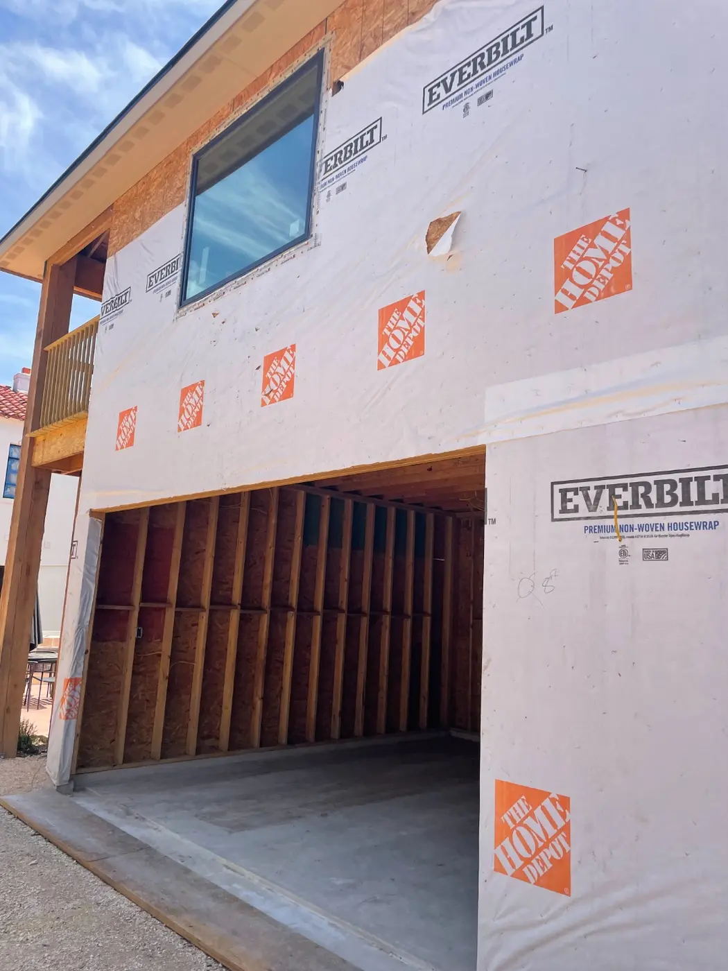 A close-up of the house wrap with the garage opening framed in