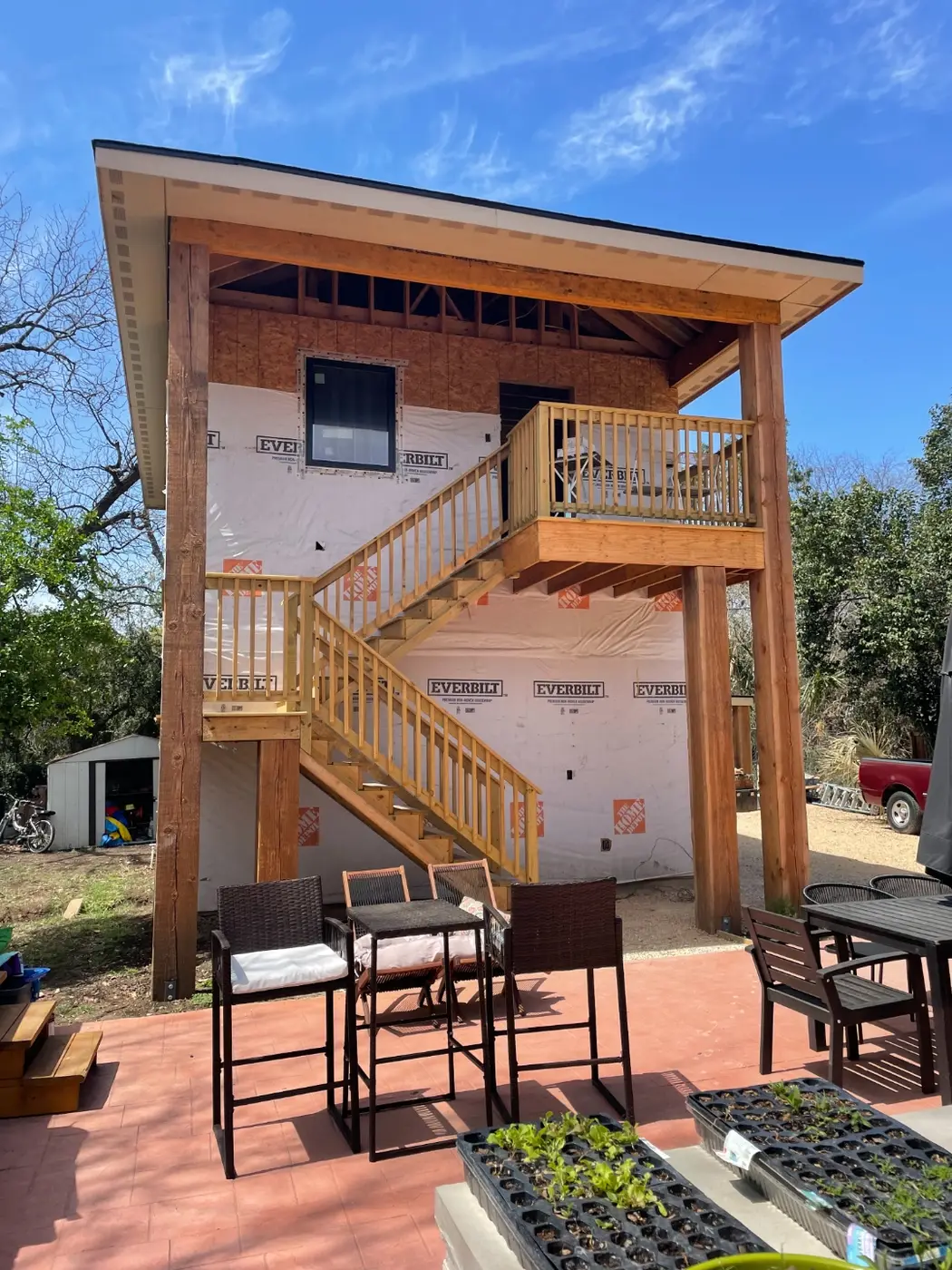 The structure wrapped in house wrap with the exterior stairs and deck built