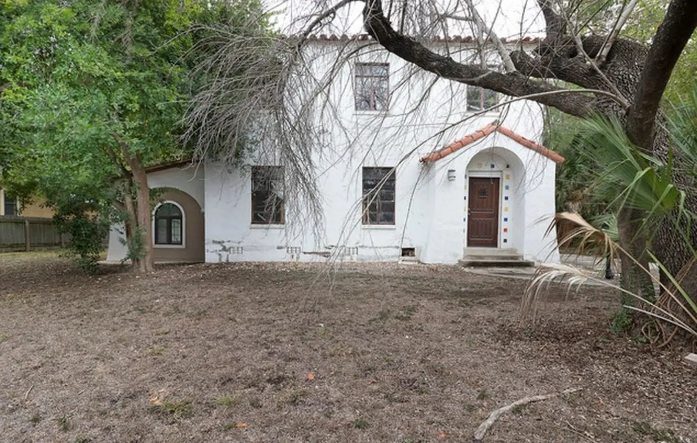 Before: the overgrown front yard and dingy white stucco exterior of the Hacienda house