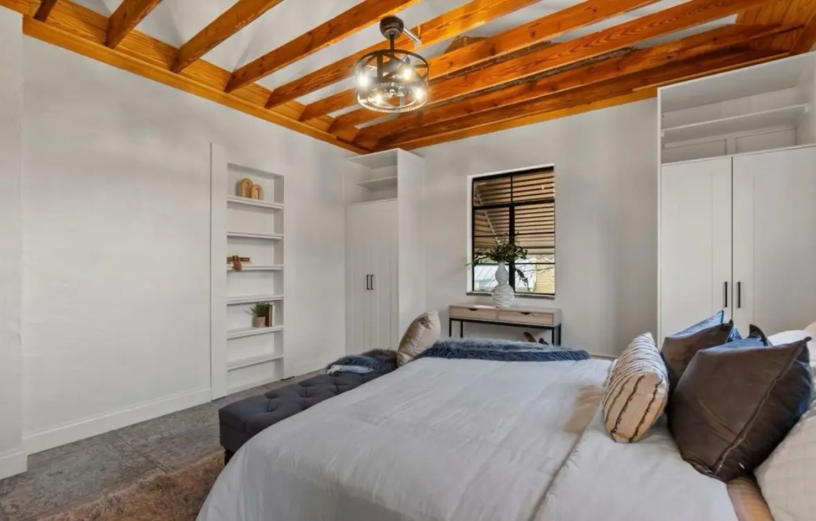 A built-in bookshelf nook and matching wardrobes in the secondary bedroom