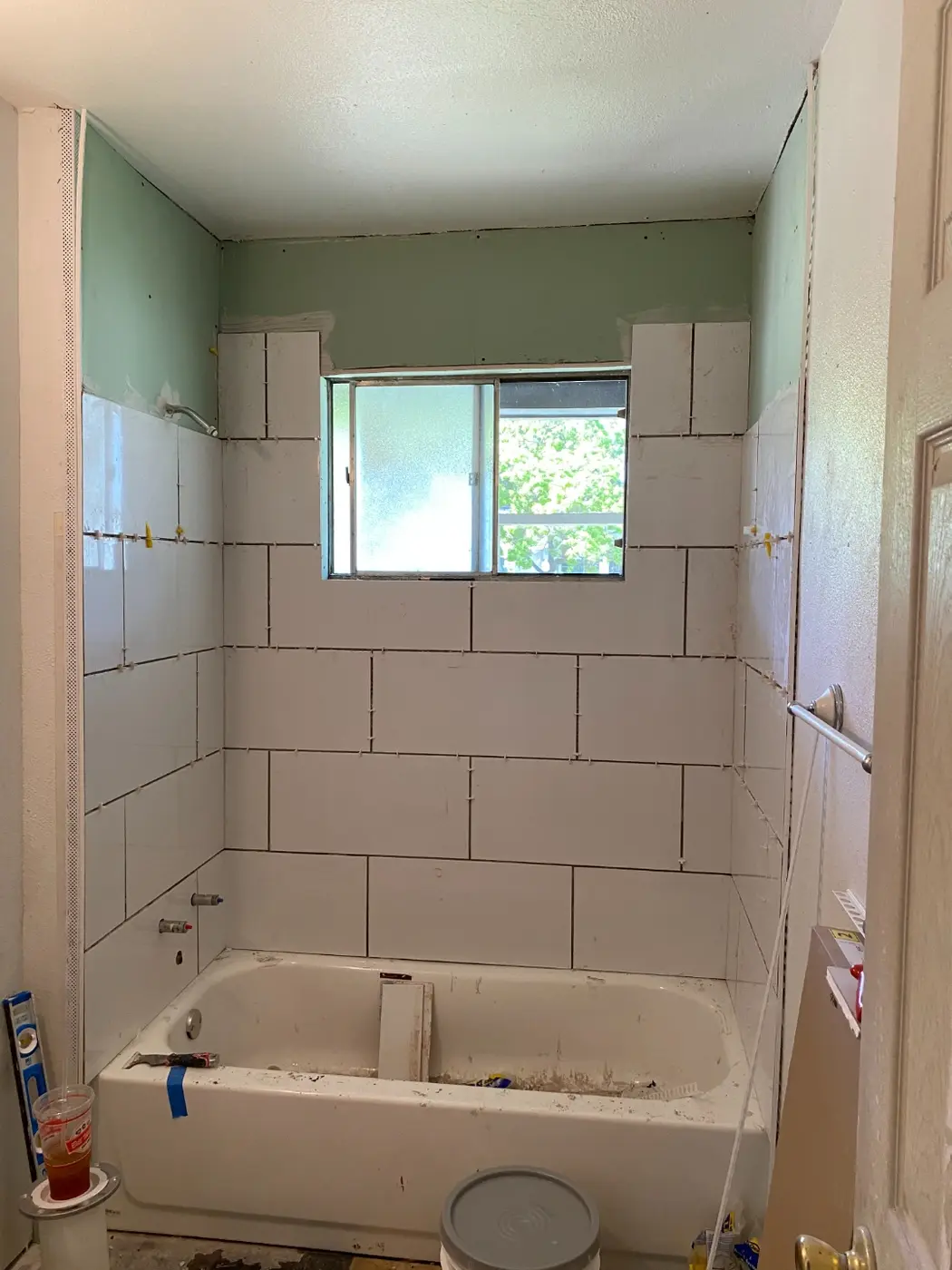 Bathroom tile surround further along, near the window