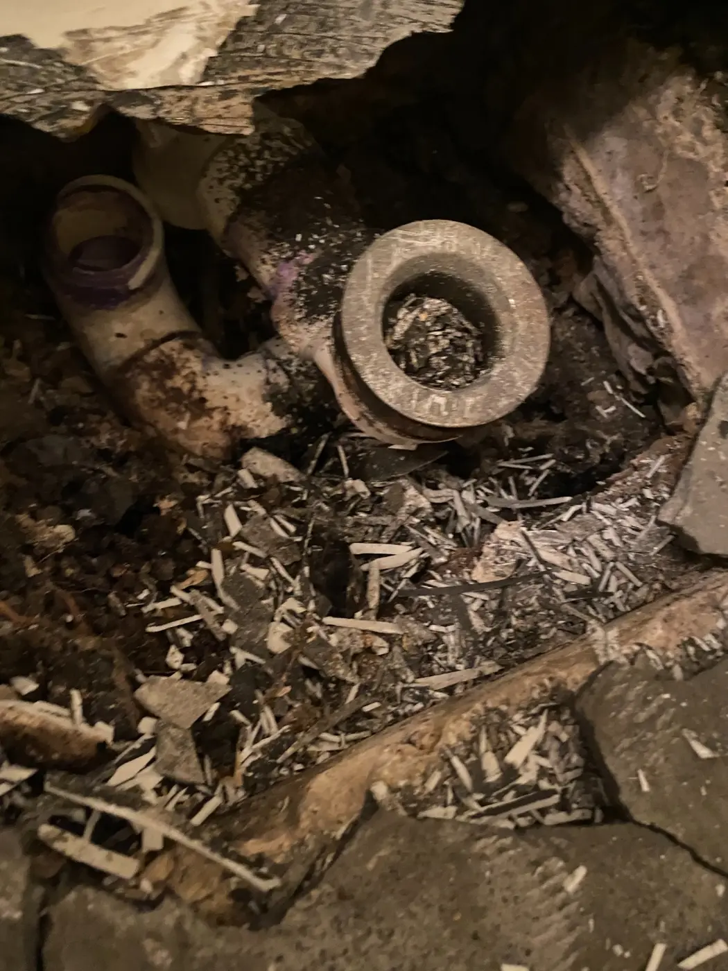Close-up of the detached drain pipe found beneath the bathtub