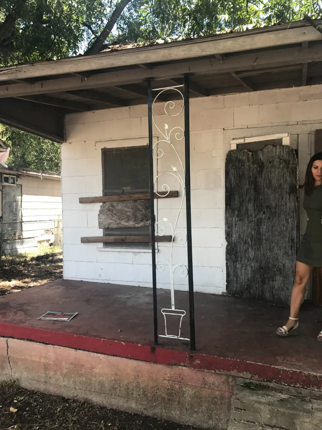 Before: Anna standing in the doorway of the dilapidated house, assessing the work ahead