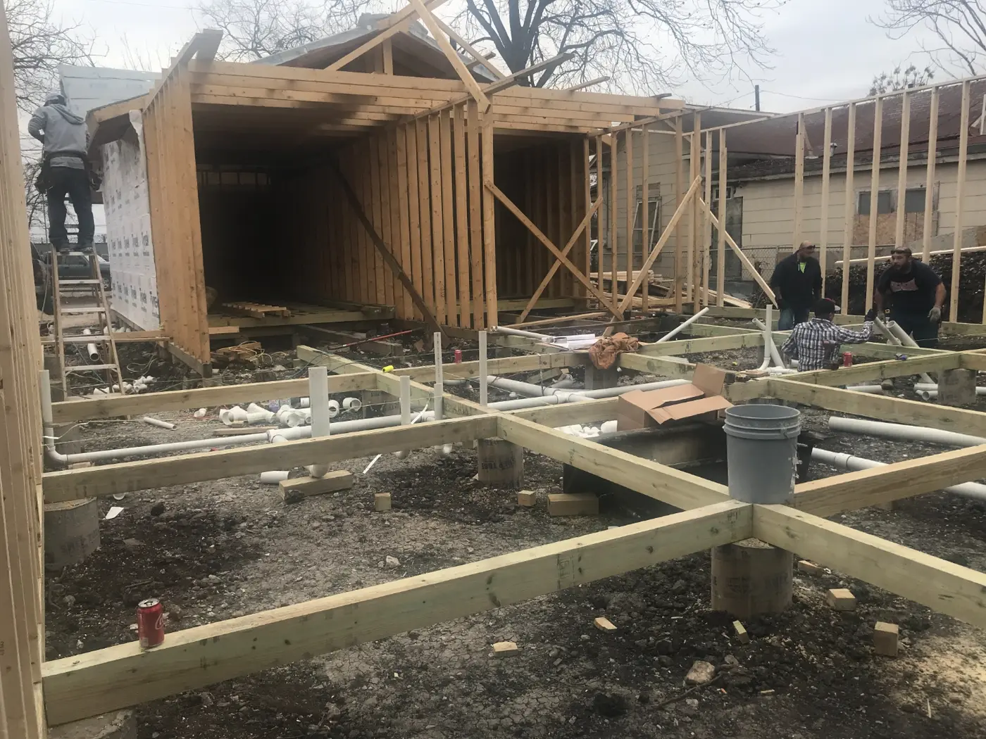 During: the crew framing the new foundation and walls in winter