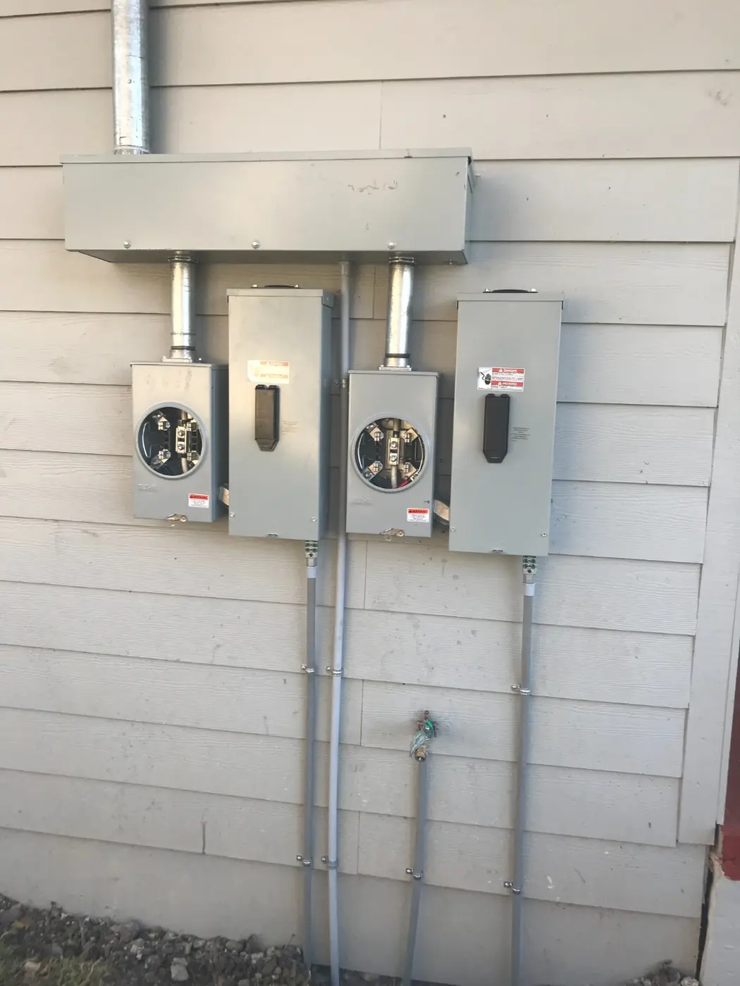 Two separate electric meters mounted side by side, confirming the duplex conversion
