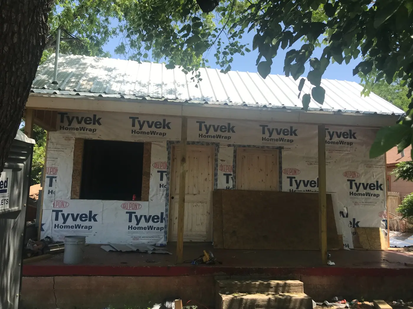 During: the new metal roof and Tyvek house wrap going on