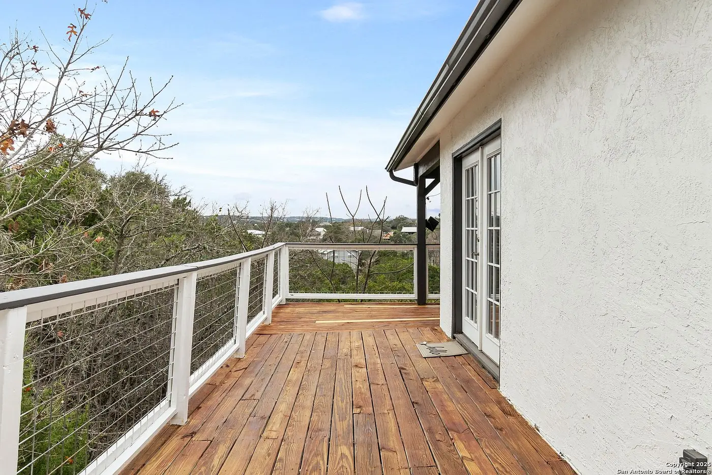 After: the same deck with the decking restained a rich brown and the railing repainted