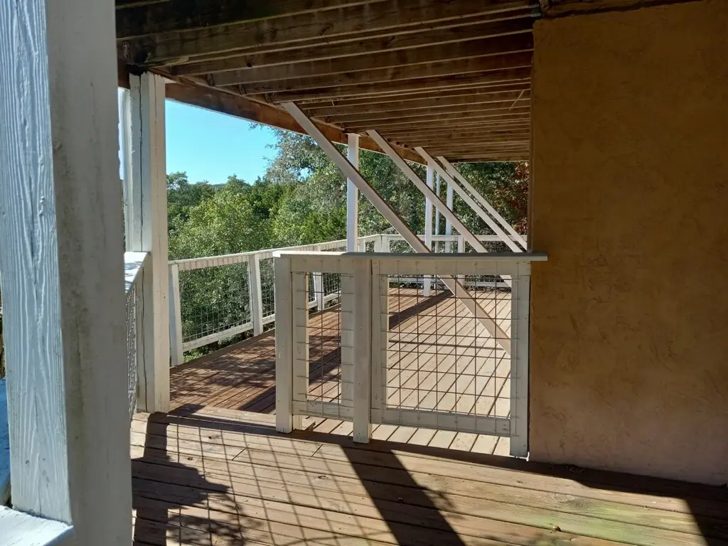 Before: the deck with a bare wire and wood railing and unfinished decking