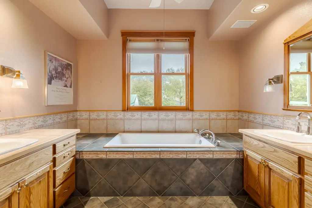 Before: a primary bathroom with mauve pink walls and dated vanities
