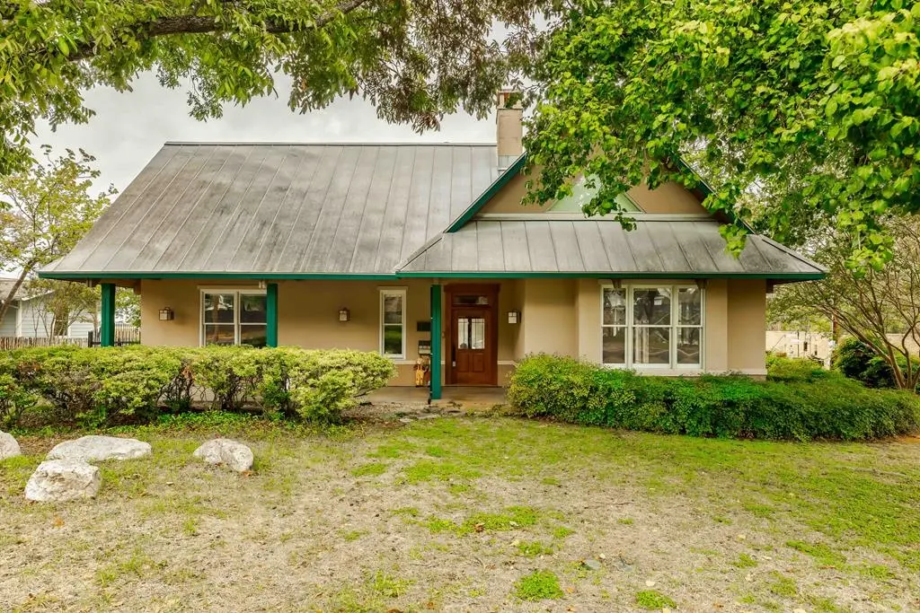 Before: the front of the Travis house with sparse, patchy landscaping and bare dirt patches in the yard