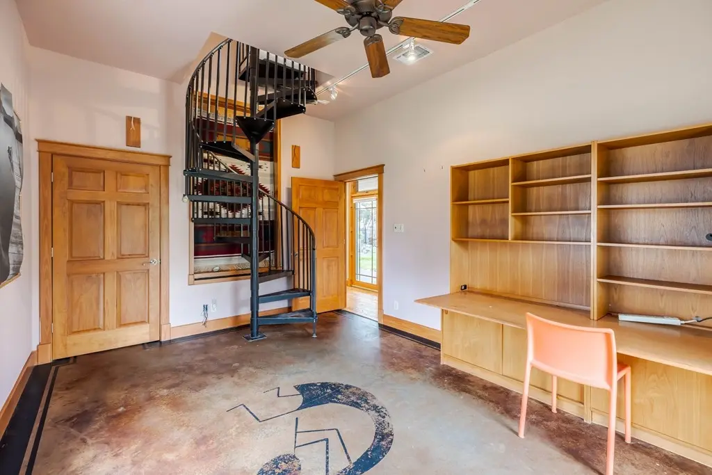 Before: an empty loft office with a black spiral staircase, bare concrete floors, and empty built-in shelving